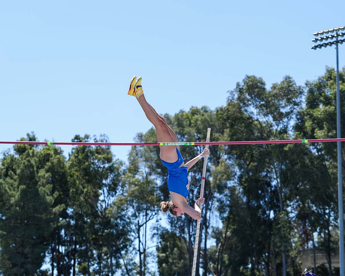women's pole vaulter making it over the bar